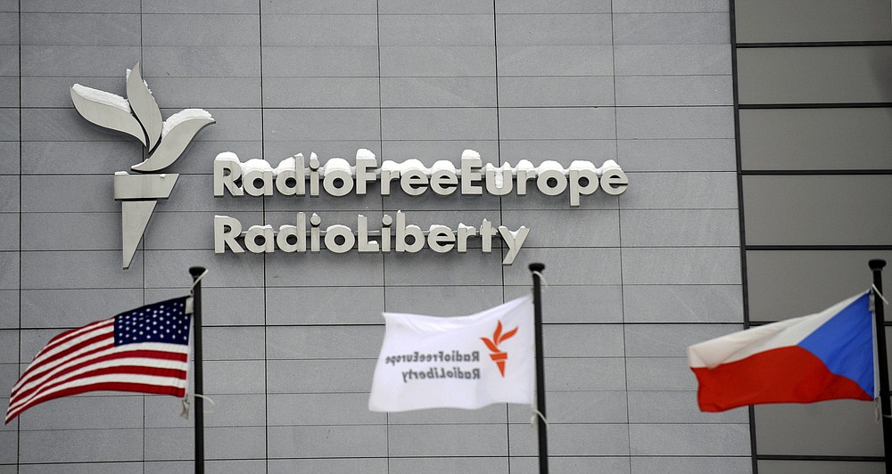 FILE - In this Jan. 15, 2010, file photo, the headquarters of Radio Free Europe/Radio Liberty is seen with U.S., RFE/RL and the Czech Republic flags in the foreground in Prague. The heads of three federally-funded international broadcasters were abruptly fired late Friday, Jan. 22, 2021, as the Biden administration completed a house-cleaning of Donald Trump appointees at the U.S. Agency for Global Media. Two officials familiar with the changes said the acting chief of the USAGM summarily dismissed the directors of Radio Free Europe/Radio Liberty, Radio Free Asia and the Middle East Broadcasting Networks just a month after they had been named to the posts. (Michal Kamaryt/CTK via AP, File)