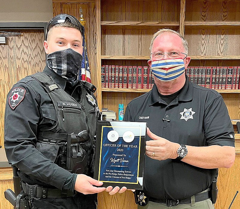 Police Chief Lynn Hahn, right, presented a plaque to officer Wyatt Varner who was selected Officer of the Year 2020 by his peers.