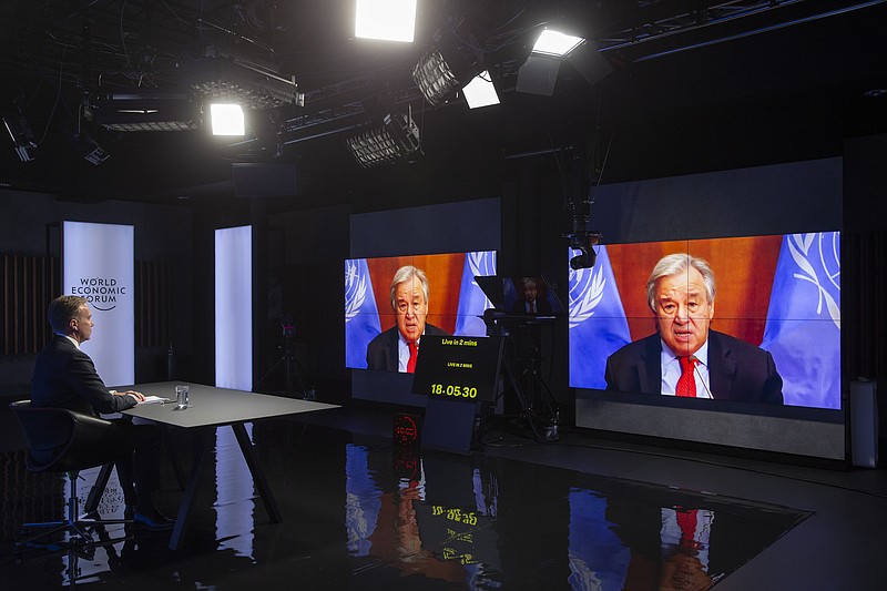 Norwegian Borge Brende, left, President and Member of the Managing Board of the World Economic Forum (WEF) speaks U.N. Secretary-General Antonio Guterres via videolink during the Davos Forum, in Cologny near Geneva, Switzerland, Monday, Jan. 25, 2021. U.N. Secretary-General Antonio Guterres is warning global leaders that the world not only faces a COVID-19 emergency and the worst economic crisis in nearly a century but “existential threats” to the climate and biodiversity. He said it also faces the possibility of the largest economies, the United States and China, splitting the world in two.  (Salvatore Di Nolfi/Keystone via AP)