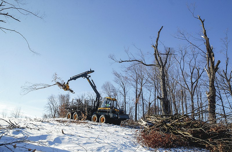 An operator uses a forwarder to pick up and remove tree limbs and other debris from areas of Ellis Park Golf Course in Cedar Rapids, Iowa, on Tuesday, Jan. 12, 2021. (Jim Slosiarek/The Gazette via AP)