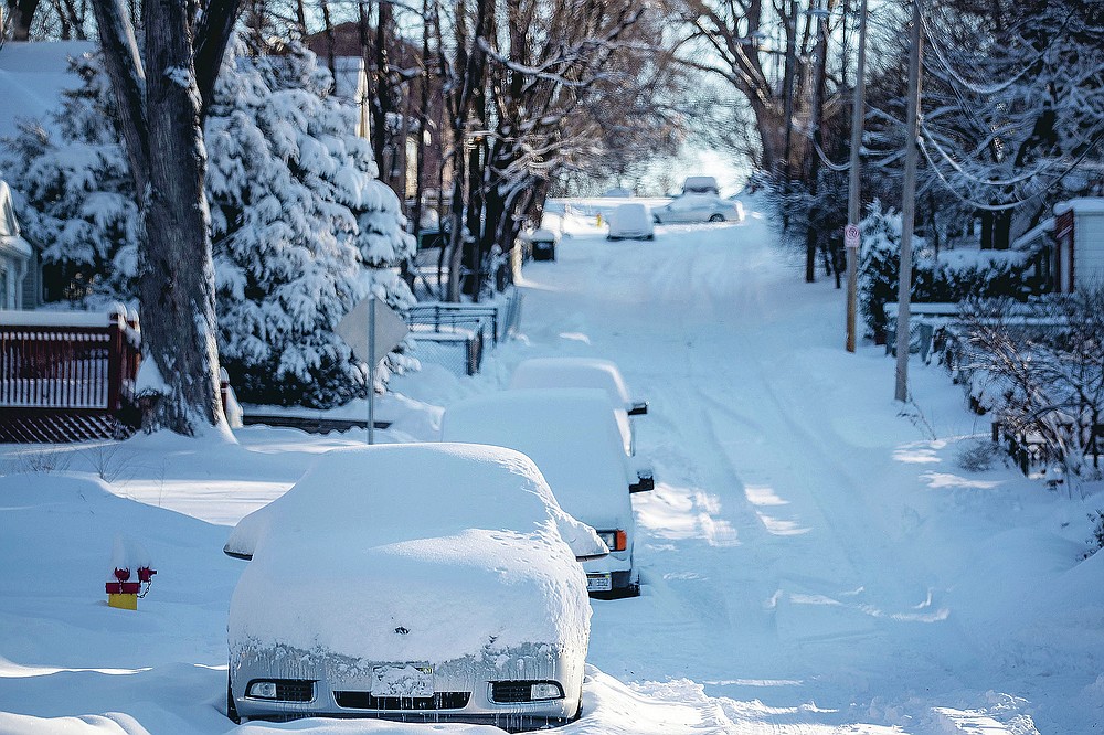 Snow covers cars and Blondo Street east of Northwest Radial Highway in Omaha, Neb., on Tuesday, Jan. 26, 2021. The Omaha area recorded almost 12 inches of snow the day before. (Chris Machian/Omaha World-Herald via AP)