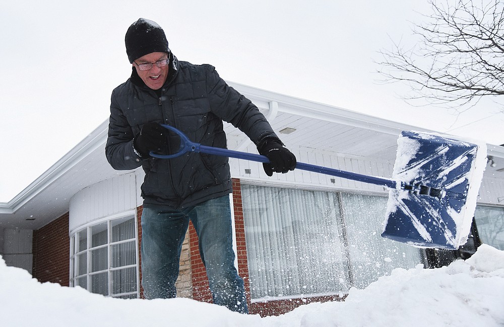 Mike Siri removes snow from in front of The Relationship Center in downtown Wauconda, Ill., Tuesday, Jan. 26, 2021. (Paul Valade/Daily Herald via AP)