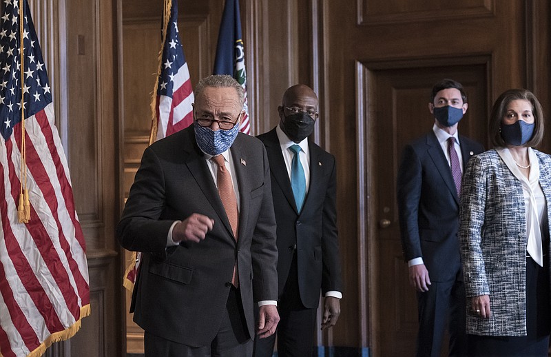 On the first full day of the Democratic majority in the Senate, Majority Leader Chuck Schumer, D-N.Y., left, is joined by Sen. Raphael Warnock, D-Ga., center, and Sen. Jon Ossoff, D-Ga., with Sen. Catherine Cortez Masto, D-Nev., who chaired the Democratic Senatorial Campaign Committee, far right, at the Capitol in Washington, Thursday, Jan. 21, 2021. The pivotal Georgia runoff election this month was decisive in handing Democrats the majority in the Senate. (AP Photo/J. Scott Applewhite)