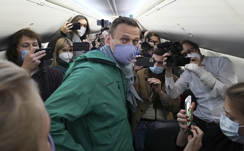 FILE - In this Jan. 17, 2021, file photo, Alexei Navalny is surrounded by journalists inside the plane prior to his flight to Moscow in the Airport Berlin Brandenburg (BER) in Schoenefeld, near Berlin, Germany. Allies of Navalny are calling for new protests next weekend to demand his release, following a wave of demonstrations across the country Saturday, Jan. 23, that brought out tens of thousands in a defiant challenge to President Vladimir Putin. (AP Photo/Mstyslav Chernov, File)