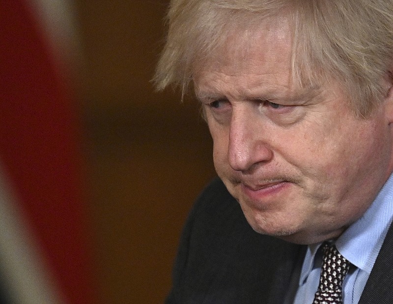 Britain's Prime Minister Boris Johnson leaves the podium after leading a virtual press conference on the Covid-19 pandemic, inside 10 Downing Street in central London Tuesday Jan. 26, 2021.  Official data shows that more than 100,000 people have died after testing positive for coronavirus in Britain, since the pandemic took hold last year. (Photo by JUSTIN TALLIS / POOL / AFP)