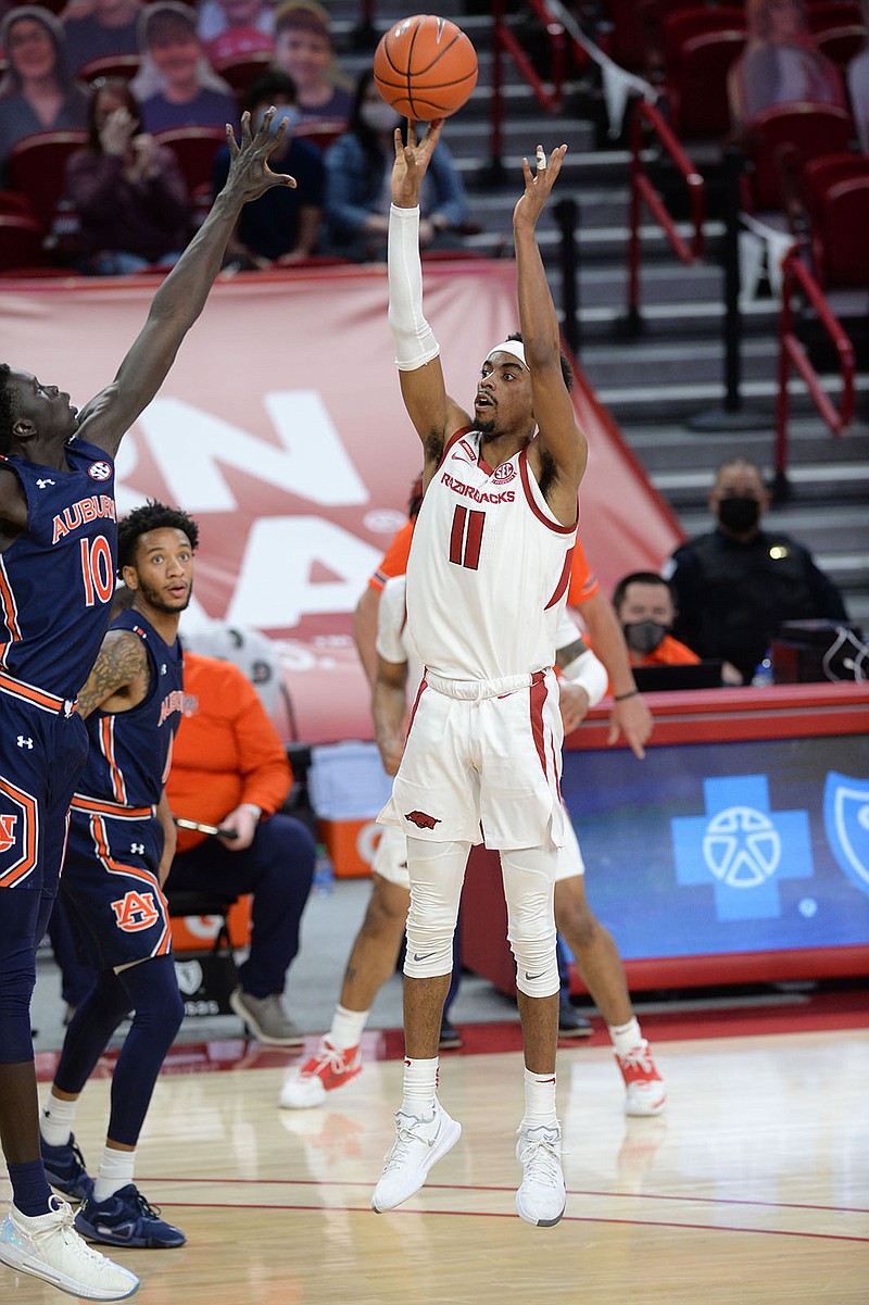 Arkansas guard Jalen Tate (11) takes a 3-point shot over Auburn forward JT Thor (10) during the first half of a Jan. 20 game in Bud Walton Arena in Fayetteville. - Photo by Andy Shupe of NWA Democrat-Gazette