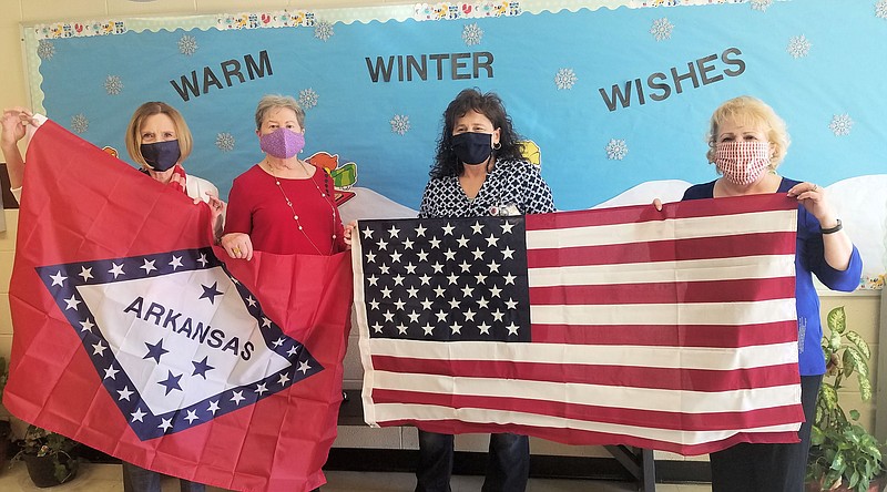 U.S.D. 1812 members Mary Willmuth and Judy Robbins hold the Arkansas flag and Donna Whisenhunt, principal, and U.S.D. 1812 Chapter President Pat McLemore hold the U.S. flag, recently. Not pictured is Sheila Beatty-Krout, honorary state regent U.S.D. 1812. - Submitted photo