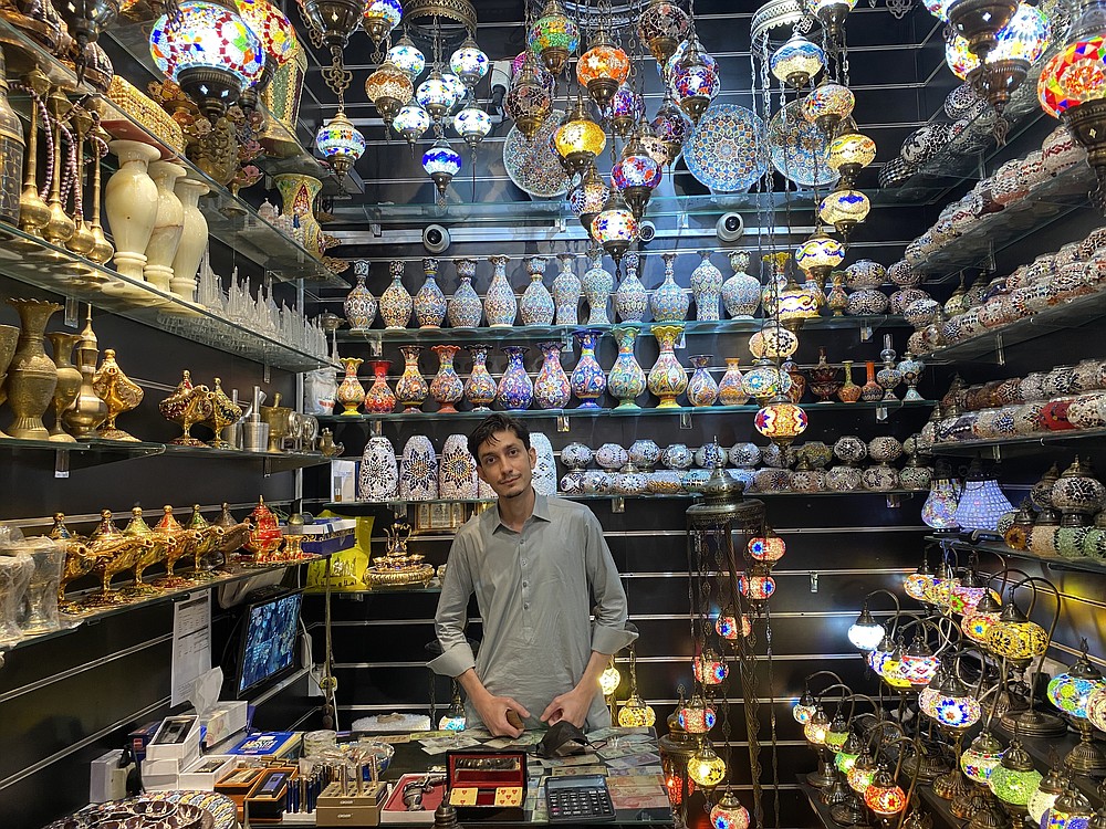 Yousaf Khan, 21, tends his shop in the Old Souk, in Dubai. MUST CREDIT: Photo by Katie McQue for The Washington Post.