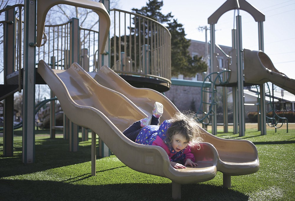 Lynette Henley, 3, of Springdale rides down a slide,¬†Friday, January 23, 2022 at Dave Peel Park in Bentonville. Bentonville residents could be asked to approve $266 million in bonds for street and park improvements as well as other capital projects in the city. The renovations at Dave Peel Park would include the playground, restroom and plaza area. 
(NWA Democrat-Gazette/Charlie Kaijo)