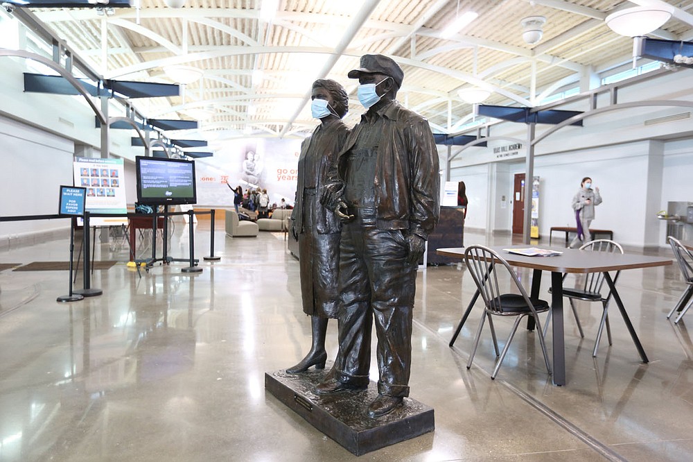 The statues of Harvey and Bernice Jones are visible Friday, January 15, 2021, inside the lobby are of the Jones Center in Springdale. The Downtown Springdale Alliance is sponsoring public events for the public to share their visions of a reimagined Jones Center.
(NWA Democrat-Gazette/David Gottschalk)