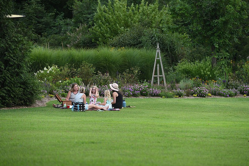 A group has a picnic Tuesday July 14, 2020 at the Botanical Garden of the Ozarks in Fayetteville. In place of the Firefly Fling Festival, which was canceled due to covid-19, the garden is hosting Magical Evenings in the Garden during the week of July 12 - 18. The garden will be open from 6:30 to 8:30 pm. Guests are invited to wear their fairy wings or costumes, bring picnics, and enjoy the garden in the cool of the evening. In order to allow proper social distancing, guest capacity will be limited. Face coverings will be required and guests must maintain a minimum of six feet from others. To reserve space visit the garden's website at www.bgozarks.org. Visit nwaonline.com/200715Daily/ for photo galleries. (NWA Democrat-Gazette/J.T. Wampler)
