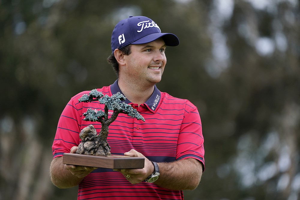 Patrick Reed stands on the South Course while holding his trophy for winning the Farmers Insurance Open golf tournament at Torrey Pines, Sunday, Jan. 31, 2021, in San Diego. (AP Photo/Gregory Bull)