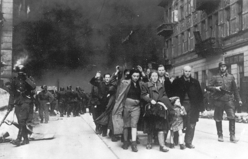 FILE - In this 1943 photo, a group of Polish Jews are led away for deportation by German SS soldiers, during the destruction of the Warsaw Ghetto by German troops after an uprising in the Jewish quarter. Two Polish historians are facing a libel trial for a scholarly examination of Polish behavior during World War II, a case whose outcome is expected to determine the fate of independent Holocaust research under Poland’s nationalist government. A verdict is expected Feb. 9. (AP Photo, B/W File)