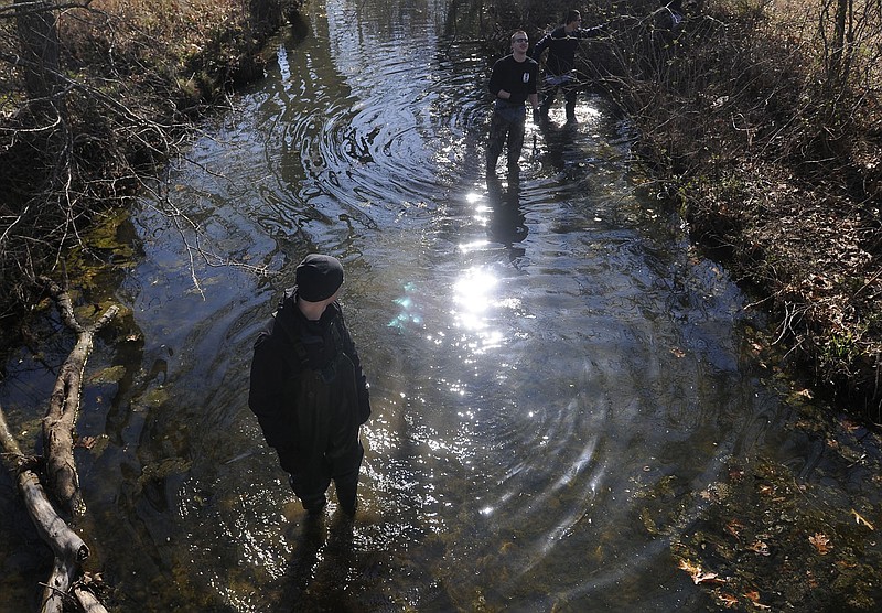 Members of the University of Arkansas' Arnold Air Society clean brush out of Hilton Creek on March 3, 2012, in Fayetteville. The City Council made a change Tuesday to the streamside protection ordinance to have any land annexed into the city be included in the map of protected waterways. (File photo/NWA Democrat-Gazette/J.S. Wedgeworth)