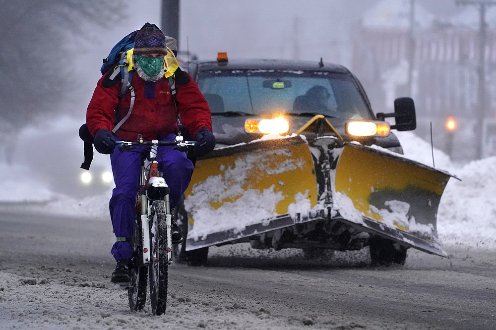 A bicyclist peddles on slick roads during a winter snow storm, Tuesday, Feb. 2, 2021, in Brunswick, Maine. (AP Photo/Robert F. Bukaty)