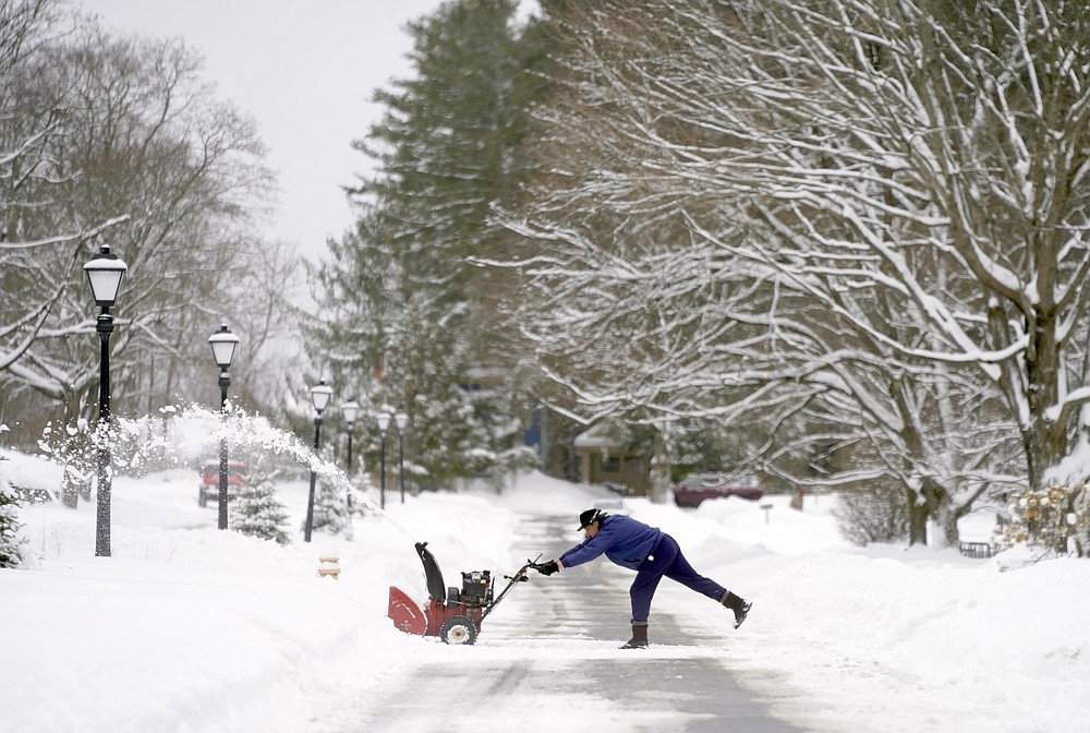A man clears snow off his driveway on Spidina Parkway in Pittsfield, Mass.,  after a snowstorm hit the East coast, Tuesday, Feb. 2, 2021. (Ben Garver/The Berkshire Eagle via AP)