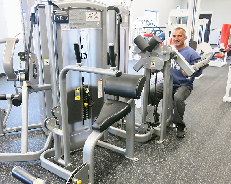 Westside Eagle Observer/SUSAN HOLLAND
Trainer Jamie McDougal, ATC, CSCS, trainer at the Gravette Gym, works out on a lateral raise machine at the gym. McDougal is available for training and his wife, physical therapist Kim McDougal, will be offering wellness services at the gym.