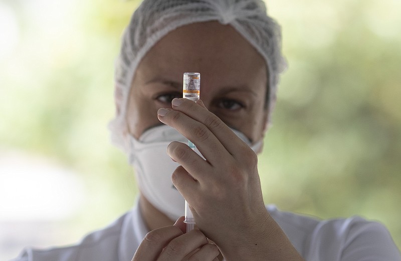 FILE - In this Feb. 1, 2021, file photo, a health worker prepares a dose of China's Sinovac CoronaVac vaccine during a priority COVID-19 vaccination program for the elderly at a drive-thru vaccination center in Rio de Janeiro, Brazil. Regulators gave conditional approval for Sinovac Biotech Ltd’s shot, CoronaVac, on Friday, Feb. 5, clearing the way for general use, The National Medical Products Administration announced in a statement Saturday, Feb. 6. (AP Photo/Silvia Izquierdo, File)