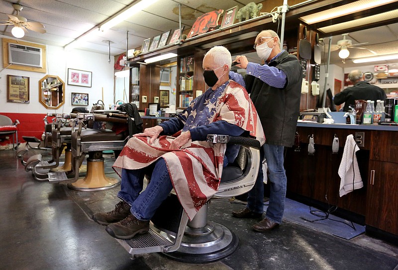 Fred Champlin, barber and co-owner of the Oak Plaza Barber Shop, gives Jimmy Lester, a 25 year customer, a hair cut Friday, January 29, 2021, at the shop in Fayetteville. Monthly sales tax reports are in for the big four cities and Benton and Washington counties. Local government finance directors are still pleased with their revenue increasing throughout the pandemic. Owners of the local Oak Plaza Barber Shop say their business isn√¢‚Ç¨‚Ñ¢t that good. Check out nwaonline.com/2101231Daily/ and nwadg.com/photos for a photo gallery.
(NWA Democrat-Gazette/David Gottschalk)