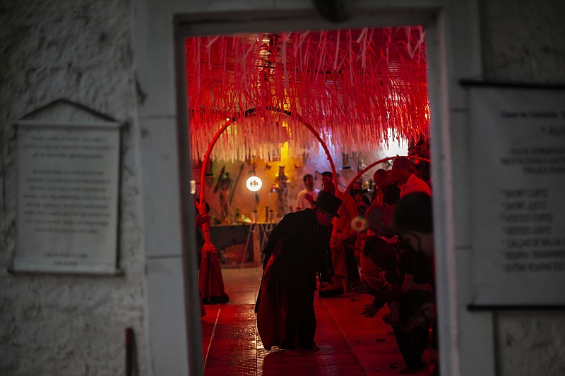 Priestess Laura D'Oya Yalorixa walks in a trance during an Umbanda religious ceremony at the Casa de Caridade Santa Barbara Iansa temple in Rio de Janeiro, Brazil, Saturday, Feb. 6, 2021. The faithful of the Umbanda religion, brought to America by West African slaves, perform spiritual protection rituals as part of pre-Carnival traditions. - AP Photo/Bruna Prado