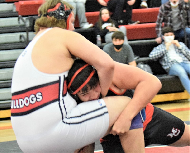 RICK PECK/SPECIAL TO MCDONALD COUNTY PRESS McDonald County's Jayce Hitt takes down Carl Junction's Kameron Bennett on the way to winning a 17-4 decision on Feb. 4 at MCHS. The Bulldogs claimed a 51-25 win in the team competition,