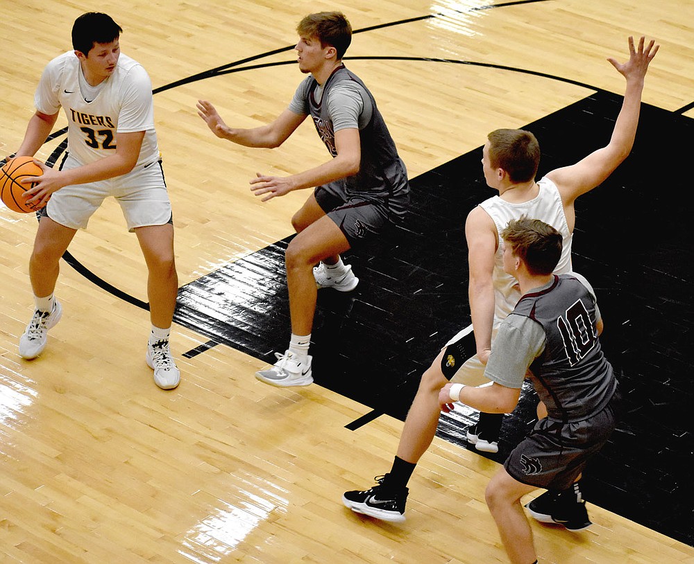 MARK HUMPHREY ENTERPRISE-LEADER/Prairie Grove forward Ethan Gross defended by Lincoln senior Tyler Brewer looks to pass the ball to guard Knox Laird posting up in the paint against Lincoln's Weston Massey during a nonconference boys basketball rivalry game against Lincoln on Tuesday, Dec. 8. The Tigers didn't exploit the mismatch on this play.