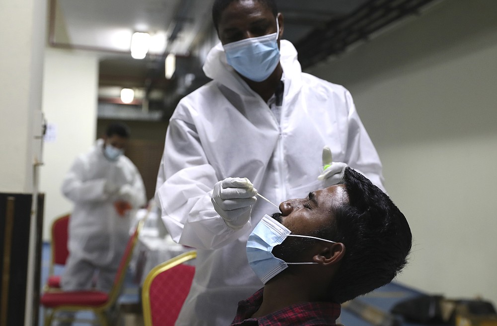A medical staff collects a nose swab sample for a polymerase chain reaction (PCR) test at the Guru Nanak Darbar Sikh Temple, in Dubai, United Arab Emirates, Monday, Feb. 8, 2021. With the coronavirus pandemic surging to new heights in the UAE, the Sikhs of Dubai have traded their traditional fare of free meals for free COVID-19 vaccines. The city's Sikh temple is administering 5,000 shots to those who may otherwise struggle to be vaccinated. (AP Photo/Kamran Jebreili)