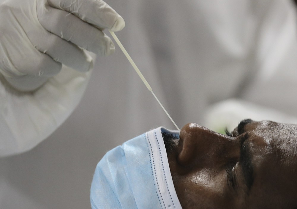 A medical staff collects a nose swab sample for a polymerase chain reaction (PCR) test at the Guru Nanak Darbar Sikh Temple, in Dubai, United Arab Emirates, Monday, Feb. 8, 2021. With the coronavirus pandemic surging to new heights in the UAE, the Sikhs of Dubai have traded their traditional fare of free meals for free COVID-19 vaccines. The city's Sikh temple is administering 5,000 shots made by state-backed Chinese firm Sinopharm to those who may otherwise struggle to be vaccinated. (AP Photo/Kamran Jebreili)