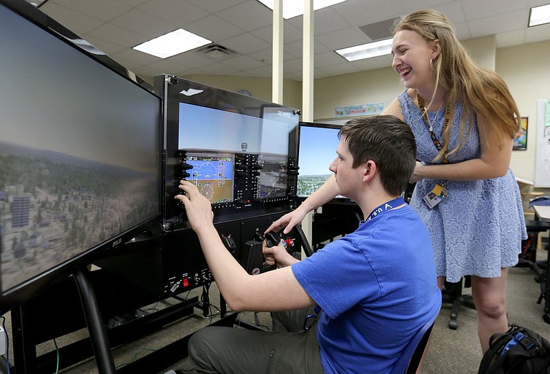 Katlyn Thompson, a senior at Har-Ber High School and first officer in the Aviation Club, helps Dylan McCuistian, a junior, take off from the city of Springdale Municipal Airport Thursday, March 12, 2020, on a flight simulator at the school in Springdale. The club acquired 15 state-of-the-art flight simulators and two teacher stations for use by its Aviation Club thanks to a grant from the Walton Family Foundation and through partnership with the Smithsonian National Air and Space Museum.(NWA Democrat-Gazette/David Gottschalk)