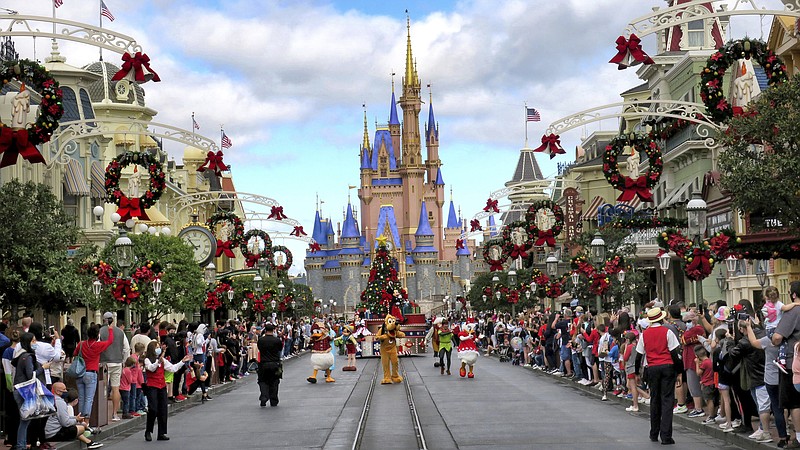 FILE - In this Dec. 21, 2020 file photo, crowds line Main Street USA, with Cinderella Castle on the horizon, to watch characters parade at the Magic Kingdom at Walt Disney World, in Lake Buena Vista, Fla. The Teamsters local that represents workers who play characters at Walt Disney World was taken over almost two years ago by its parent union, which cited “deficiencies" in the local's leadership following repeated complaints of mismanagement from members. Now a former officer of Local 385 is suing the International Brotherhood of Teamsters, claiming the takeover has lasted too long. (Joe Burbank/Orlando Sentinel via AP, File)