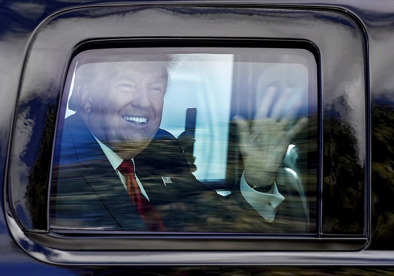 Former President Donald Trump waves to supporters as his motorcade drives through West Palm Beach, Fla., on his way to his Mar-a-Lago club in Palm Beach after arriving from Washington aboard Air Force One on Wednesday, Jan. 20, 2021. (Damon Higgins/The Palm Beach Post via AP)