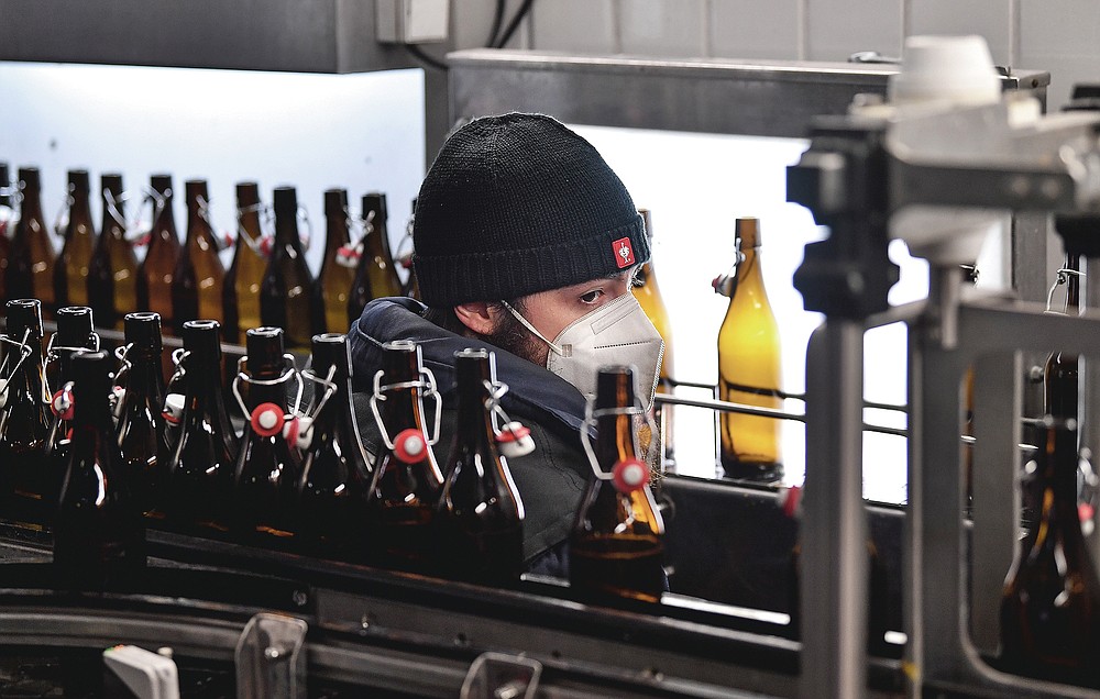 Die Mitarbeiter arbeiten in einer kleinen, familiengeführten Heller-Brauerei in Köln, Dienstag, 9. Februar 2021. Die Bars sind seit mehr als drei Monaten geschlossen, die Karnevalsfeiern wurden abgesagt und es ist nicht klar, wann sich die Situation verbessern wird.  Dies ist ein großes Problem für viele kleine deutsche Bierhersteller, die stark auf den Verkauf von Fassbier an Bars und Restaurants angewiesen sind.  (AP Foto / Martin Meissner)