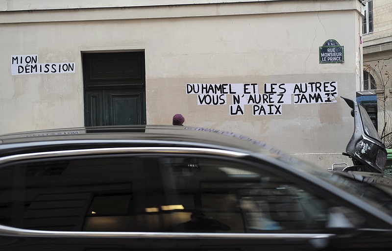 FILE - In this Jan.19, 2021 file photo, signs on the wall reads "Duhamel, and the others, you will never be in peace" referring to Olivier Duhamel, head of the National Foundation of Political Sciences, which oversees the prestigious Sciences Po university, and at left "Mion Resignation" refers to Frederic Mion, head of Sciences Po university, in Paris. France's government wants to set the age of sexual consent at 15 and make it easier to punish long-ago child sexual abuse, amid growing public pressure and a wave of online testimonies about rape and other sexual violence by parents and authority figures. (AP Photo/Francois Mori)