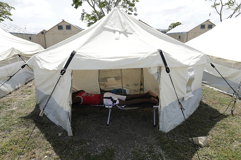 A Haitian migrant sleeps in a tent at a migrant camp amid the new coronavirus pandemic in San Vicente, Darien province, Panama, Tuesday, Feb. 9, 2021. Panama is allowing hundreds of migrants stranded because of the pandemic, to move to the border with Costa Rica, after just reopening its land borders. (AP Photo/Arnulfo Franco)