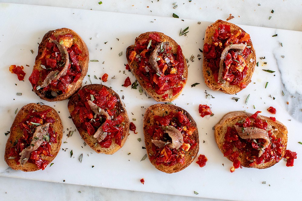 Crostini With Sun-Dried Tomato and Anchovy — The intense combination of flavors, both sweet and salty, creates an ideal savory bite. (The New York Times/Andrew Scrivani)