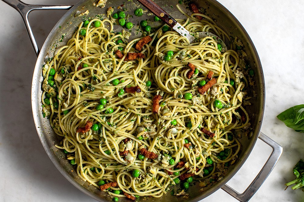 When you’re far from the sea or the fishmonger, you can reach for canned baby clams as they make a very decent main-course pasta ingredient in Spicy Clam Pasta With Bacon, Peas and Basil. (The New York Times/Andrew Scrivani)