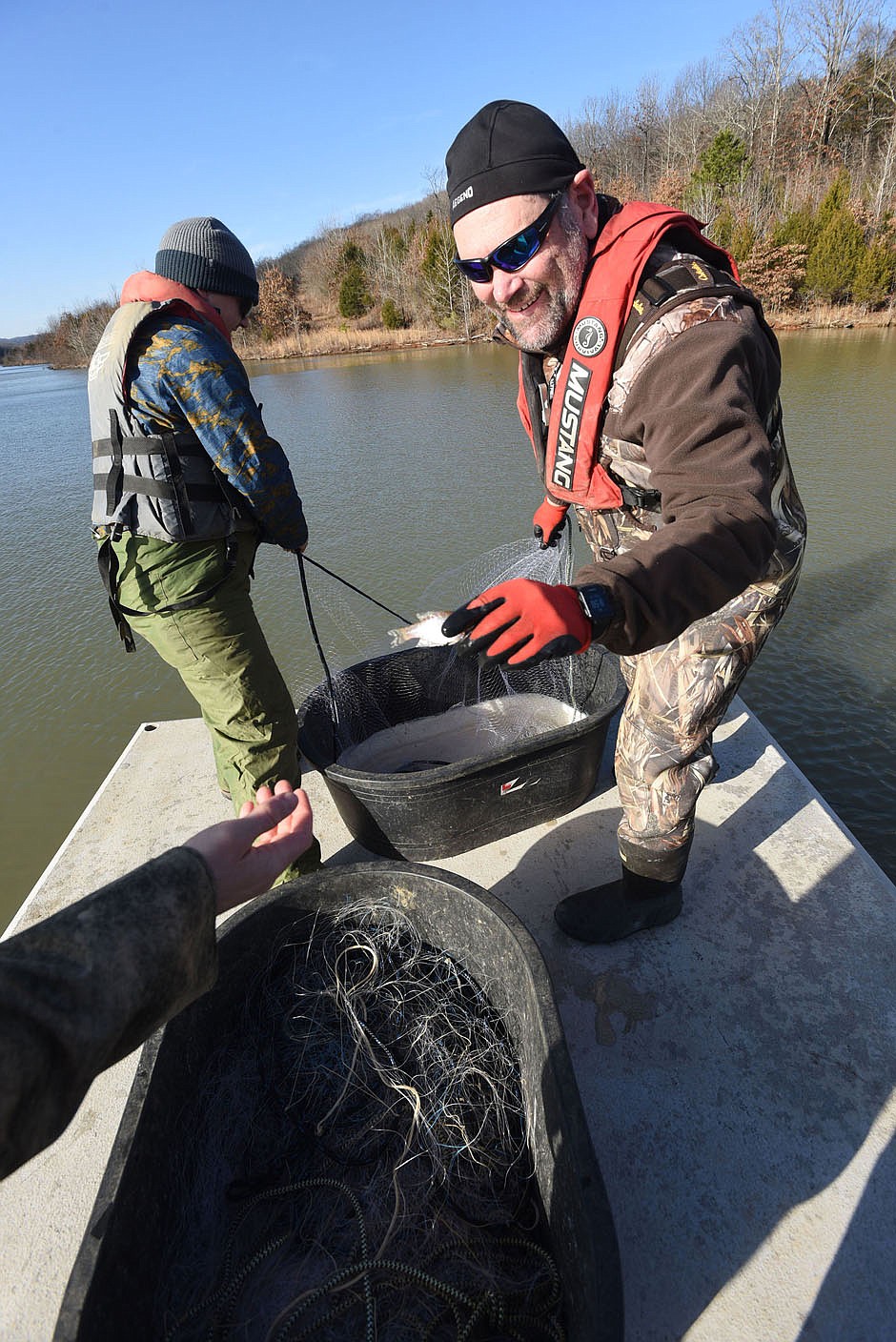 Jon Stein (right), Northwest Arkansas regional fisheries supervisor for Game and Fish, takes a small crappie from the gill net. Walleye are the focus of the study at Lake Fort Smith, but Stein also looked at crappie, white bass and other species during the research.
(NWA Democat-Gazette/Flip Putthoff)