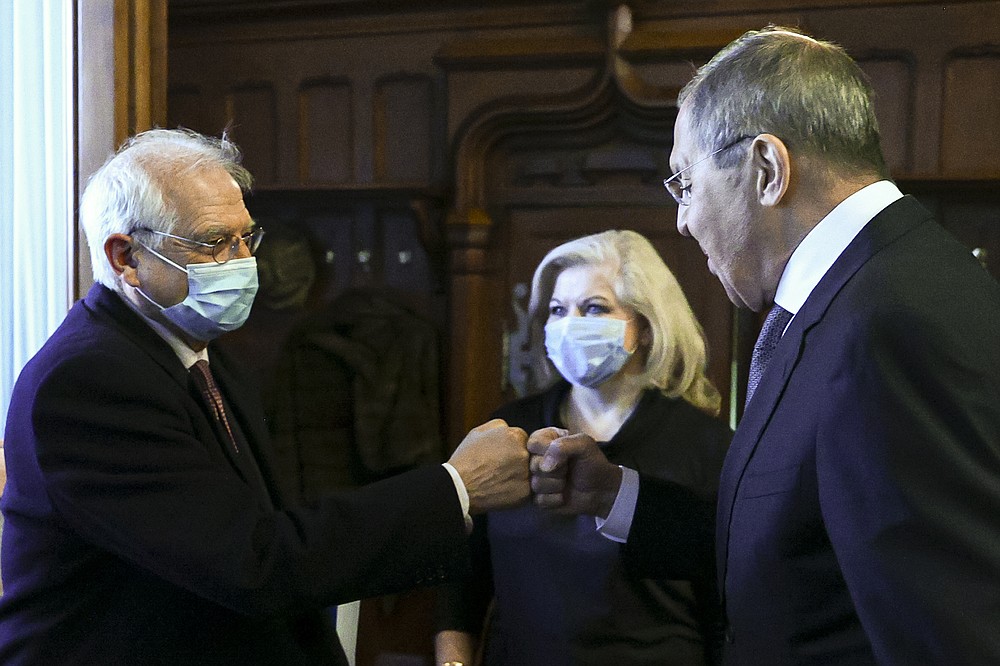 In this photo released by the Russian Foreign Ministry Press Service, Russian Foreign Minister Sergey Lavrov, right, and High Representative of the EU for Foreign Affairs and Security Policy Josep Borrell wearing a face mask to protect against coronavirus, greet each other prior to their talks in Moscow, Russia, Friday, Feb. 5, 2021. The European Union's top diplomat expressed hopes Friday that the COVID-19 vaccine developed by Russia will soon be used across the 27-nation bloc. During a visit to Moscow, EU foreign affairs chief Josep Borrell said the Sputnik V vaccine is "good news for the whole mankind." (Russian Foreign Ministry Press Service via AP)