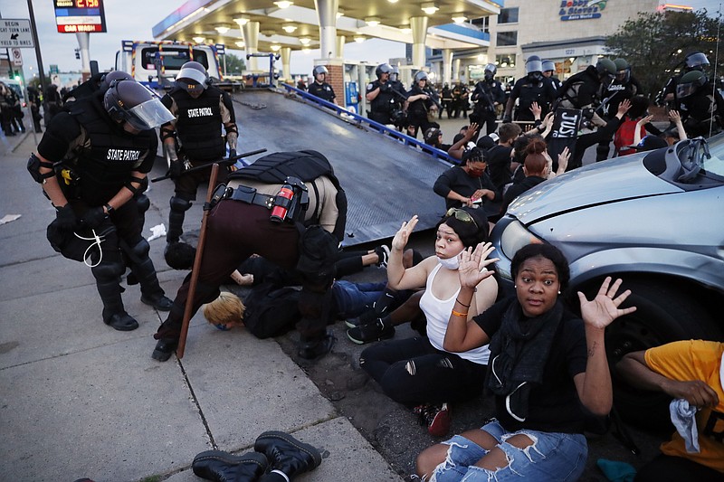 FILE - In this May 31, 2020, file photo, demonstrators are taken into custody after curfew in Minneapolis, as protests continued following the death of George Floyd, who died after being restrained by Minneapolis police officers on Memorial Day. The city of Minneapolis will spend $6.4 million to hire dozens of police officers, at a time when some City Council members and activist groups have been advocating to replace the police department in the wake of Floyd’s death. The City Council voted unanimously Friday, Feb. 12, 2021, to approve the additional funding, which police requested. (AP Photo/John Minchillo, File)