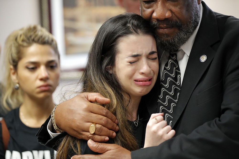 FILE- In this Feb. 21, 2018 file photo, Aria Siccone, 14, a student survivor from Marjory Stoneman Douglas High School massacre, cries as she recounts her story from that day, while state Rep. Barrinton Russell, D-Dist. 95, comforts her, as they talk to legislators at the state Capitol regarding gun control legislation, in Tallahassee, Fla. Even before the COVID pandemic upended the lives of millions of high school students, forever altering treasured milestones, homecomings, proms and graduation ceremonies, the Douglas high seniors were inextricably linked by tragedy. (AP Photo/Gerald Herbert, File)