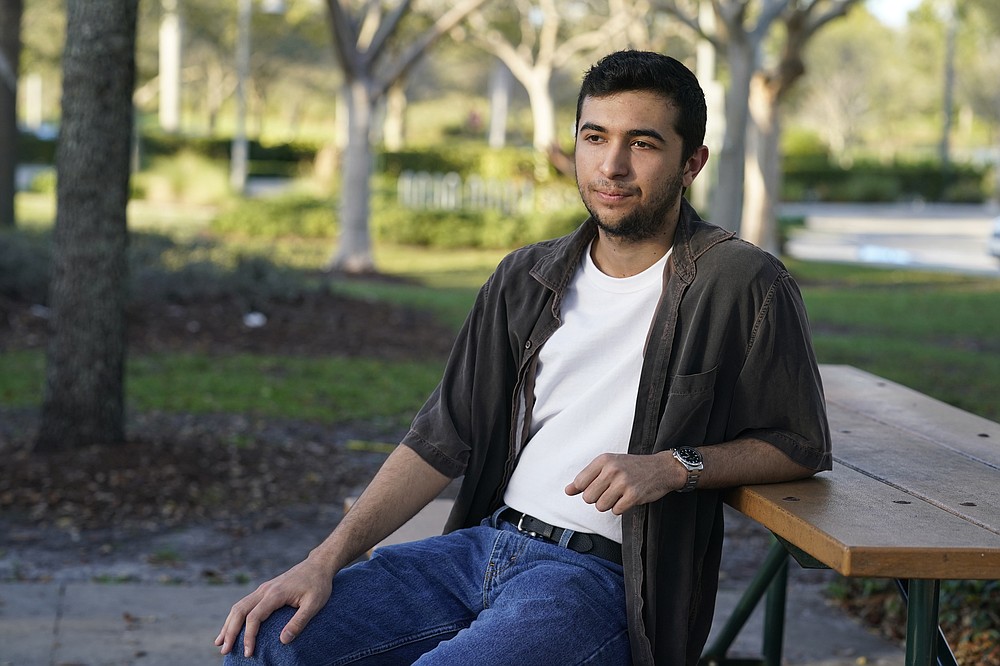 Ryan Servaites sits at a park, Thursday, Feb. 11, 2021 in Parkland, Fla. Servaites was freshman at Marjory Stoneman Douglas when the shooting occurred. He found healing in activism. He joined the student-led March For Our Lives, registering first-time voters in various states and now working on gun reform policy. He's planning to attend college and is passionate about enacting change, sounding assured and self-confident, but it's been a process. (AP Photo/Marta Lavandier)