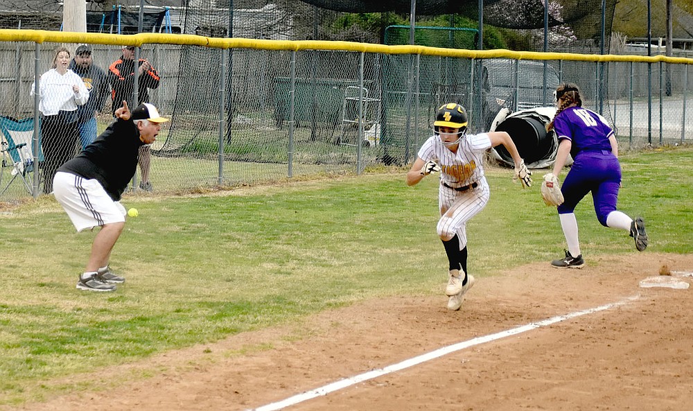 MARK HUMPHREY ENTERPRISE-LEADER/Prairie Grove softball coach Dave Torres (left) sends Charity Stearman home after a cutoff throw went past third into the fence. Stearman scored the Lady Tigers' fifth run to even the score in the bottom of the seventh. Prairie Grove rallied to win 6-5 in the 4A-1 Conference softball opener on Tuesday, March 30.