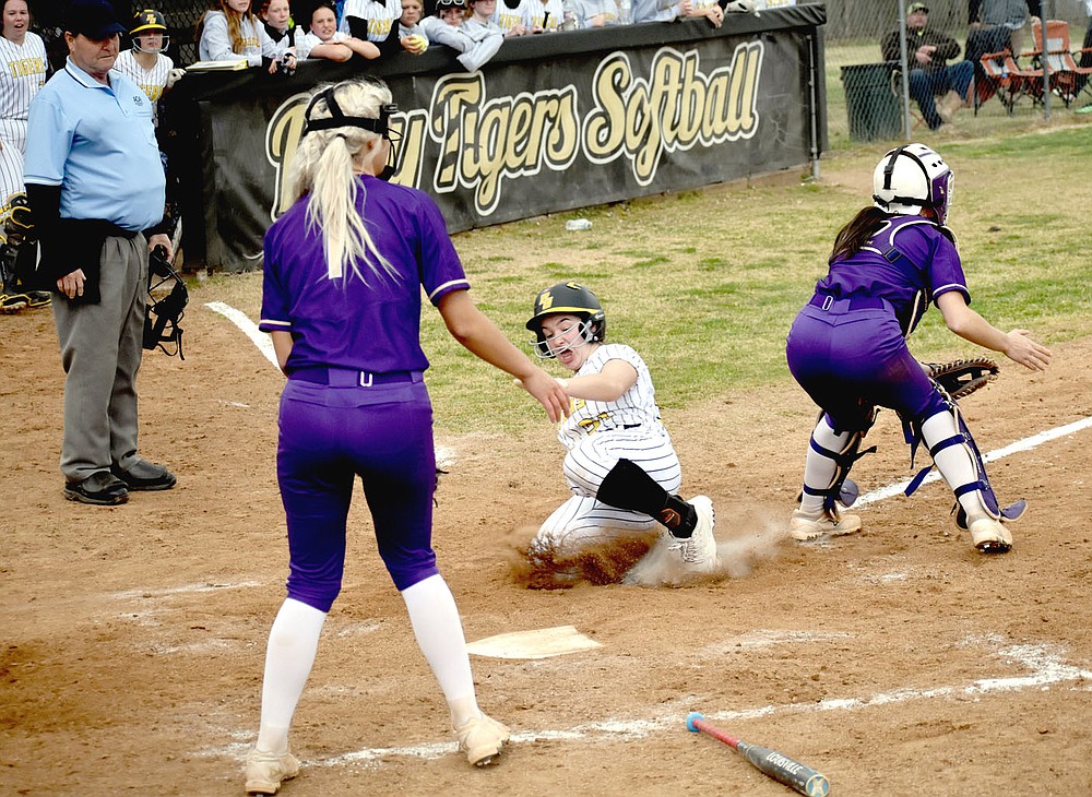 MARK HUMPHREY ENTERPRISE-LEADER/Prairie Grove senior Makinsey Parnell slides into home between Berryville's catcher and pitcher Faith Kelley backing up at the plate. Parnell took off from second when teammate Kelsey Pickett doubled. The throw to the plate veered off towards Prairie Grove's dugout. Parnell's run won the 4A-1 Conference softball opener for Prairie Grove, 6-5, on Tuesday, March 30.