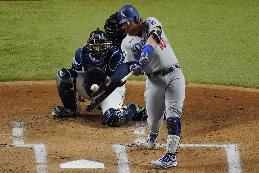 FILE - In this Oct. 24, 2020, file photo, Los Angeles Dodgers' Justin Turner hits a home run against the Tampa Bay Rays during the first inning in Game 4 of the baseball World Series in Arlington, Texas. Turner is returning to the Dodgers, announcing via Twitter that he’s ready to “run it back” with the World Series champions. (AP Photo/Sue Ogrocki, File)
