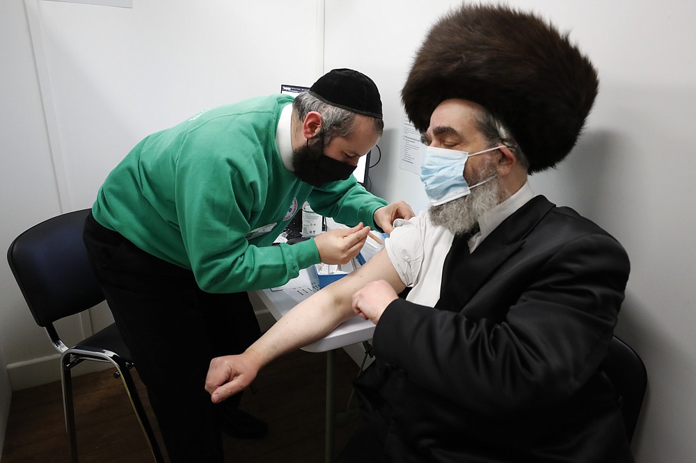 Rabbi Bieberfeld receives a dose coronavirus vaccine at the John Scott Vaccination Centre in London, Saturday, Feb. 13, 2021. The dose was administered at an event to encourage vaccine uptake in Britain's Haredi community which has been hard hit during the COVID-19 pandemic. (AP Photo/Frank Augstein)