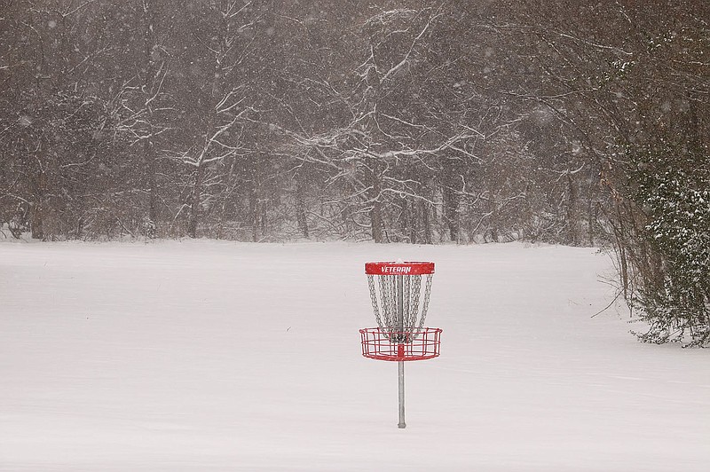 LYNN KUTTER ENTERPRISE-LEADER Western Washington County received 5-6 inches of snow Sunday and Monday during the winter storm that came through Arkansas and many other parts of the country. This hole for the Farmington Creekside Park Disc Golf Course off Broyles Avenue sets all alone surrounded by snow.