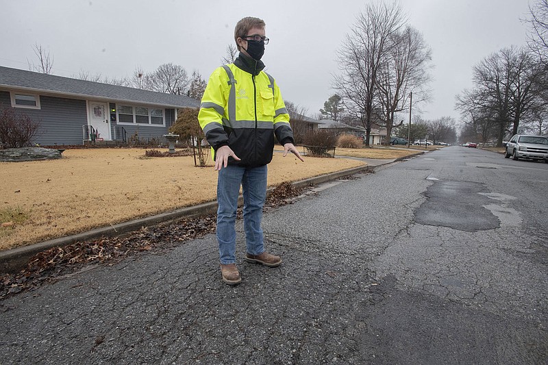 Ryan Carr, deputy director of engineering operations for the city of Springdale, points out problems with the pavement at the corner of  Shipley St. and Porter Ave. in Springdale Monday Feb. 8, 2021. (NWA Democrat-Gazette/J.T. Wampler)