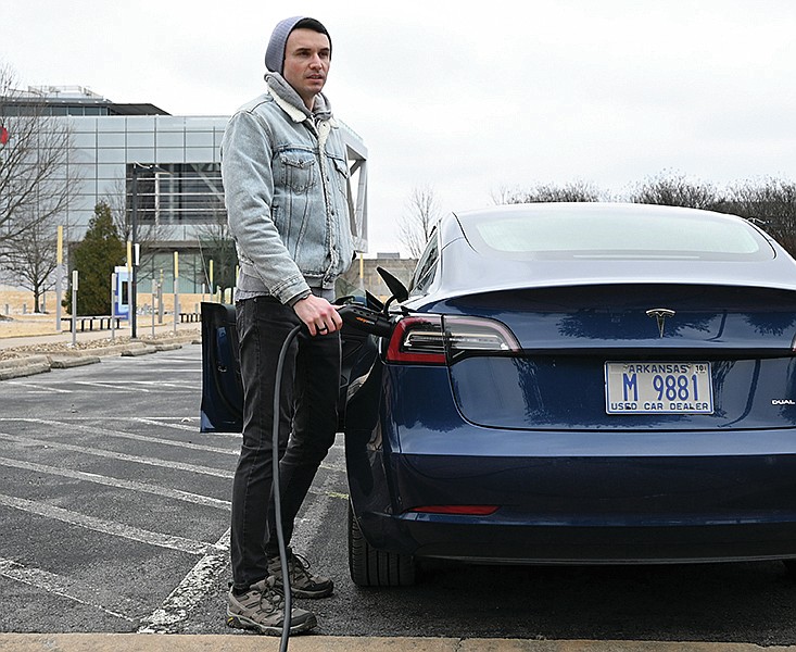 Jay Ward, president of EV Arkansas Chapter, an informal club for electric vehicles, charges his Tesla 3 outside the Clinton Center on Friday, Feb. 12, 2021. Arkansas Energy and Environment is hoping to convince apartment complexes, workplaces, and other properties to apply for funds to get Arkansas a strong electric vehicle charging infrastructure.

(Arkansas Democrat-Gazette/Stephen Swofford)