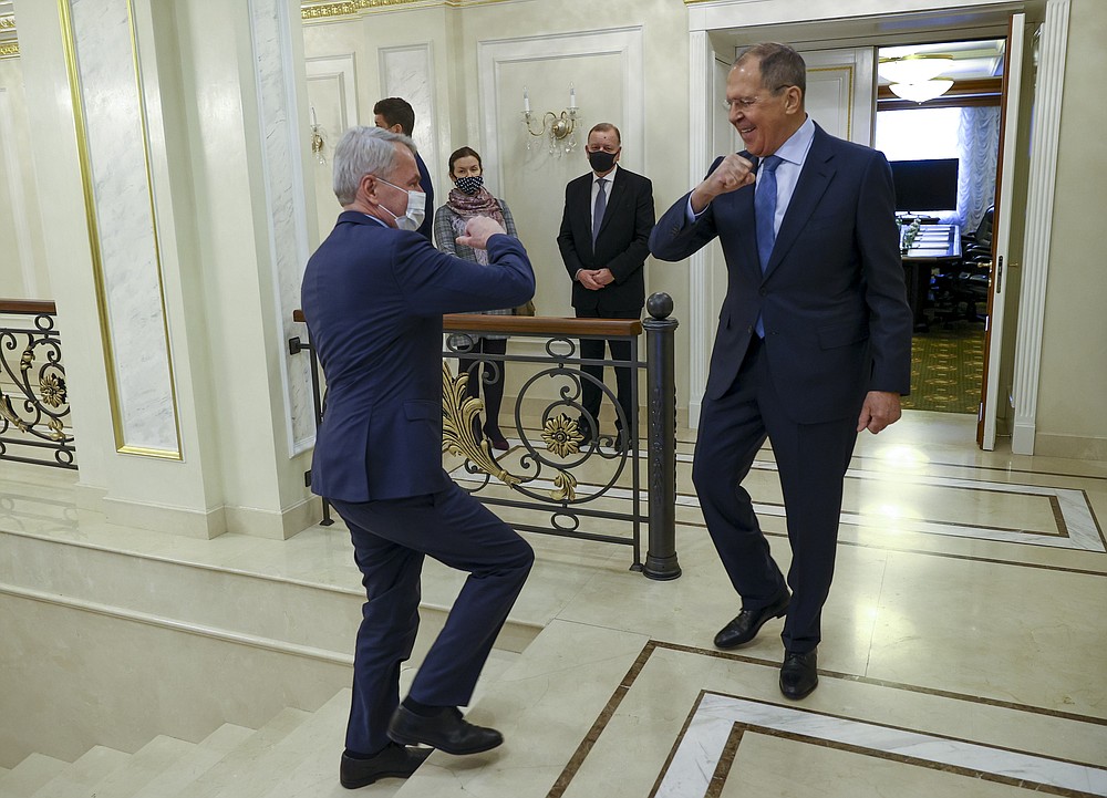 In this handout photo released by Russian Foreign Ministry Press Service, Finnish Foreign Minister Pekka Haavisto, left, and Russian Foreign Minister Sergey Lavrov, both wearing face masks to protect against coronavirus greet each other prior to their talks in St. Petersburg, Russia, Monday, Feb. 15, 2021. Lavrov blamed the European Union for a freeze in ties and argued that Moscow remains ready to mend relations. (Russian Foreign Ministry Press Service via AP)