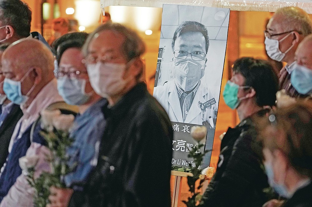 FILE - In this Feb. 7, 2020 file photo, people wearing masks attend a vigil for Chinese doctor Li Wenliang, in Hong Kong. The outpouring of grief and rage sparked by Li's death was an unusual - and for the Chinese Communist Party, unsettling - display in China's tightly monitored civic space. (AP Photo/Kin Cheung, File)